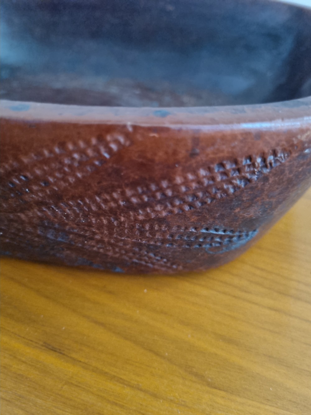 An oval 19th-century reddish-brown stoneware cooking dish featuring incised leaf patterns carved along the exterior side. View V