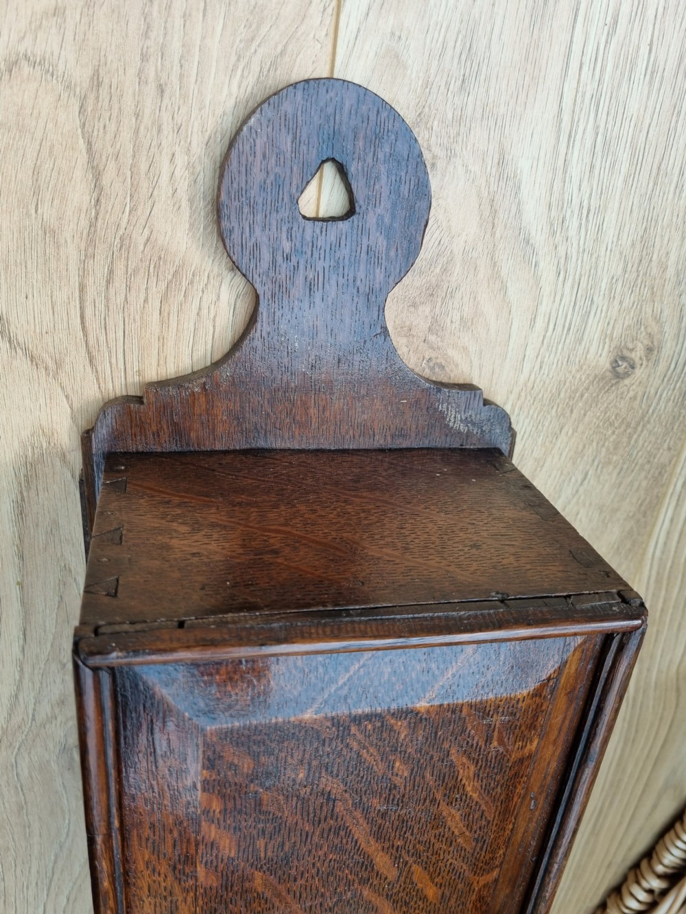 An antique dark oak hanging candle box featuring a shaped backboard with a wall-mounting aperture and a sliding front panel. View III