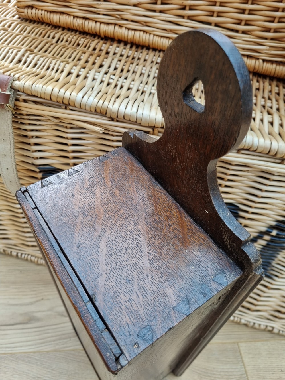 An antique dark oak hanging candle box featuring a shaped backboard with a wall-mounting aperture and a sliding front panel. View V
