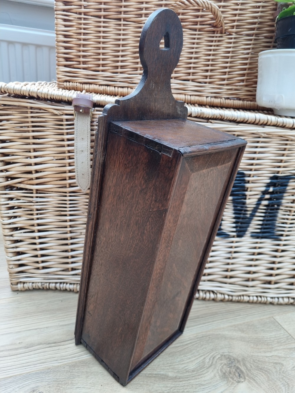 An antique dark oak hanging candle box featuring a shaped backboard with a wall-mounting aperture and a sliding front panel. View VII
