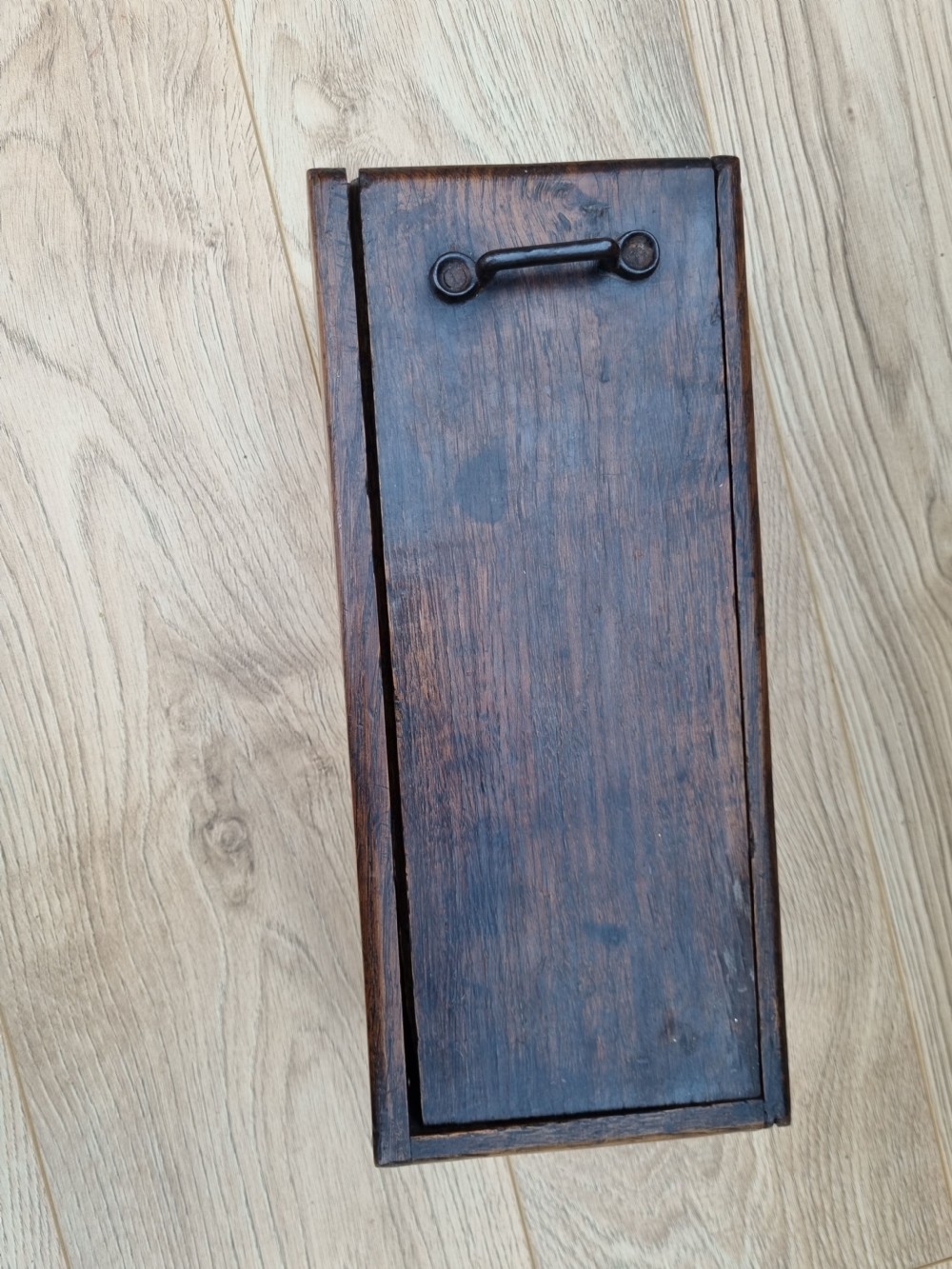 A rectangular dark oak primitive hanging candle box featuring a sliding lid with an iron handle. View VI