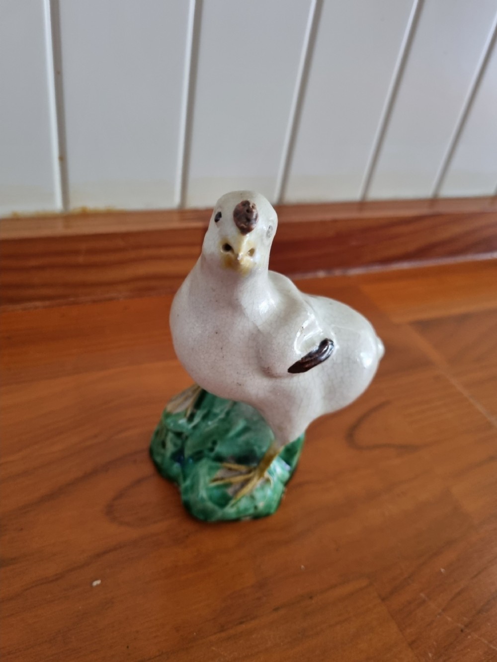 A late 18th-century Prattware glazed ceramic figure of a chicken standing on a textured green base.