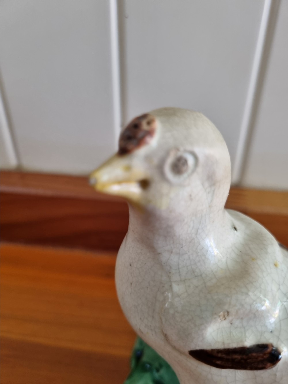 A late 18th-century Prattware glazed ceramic figure of a chicken standing on a textured green base. View II