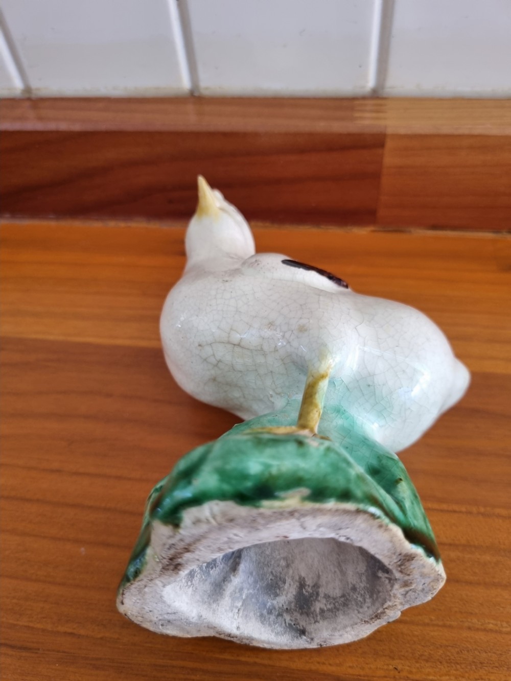 A late 18th-century Prattware glazed ceramic figure of a chicken standing on a textured green base. View III