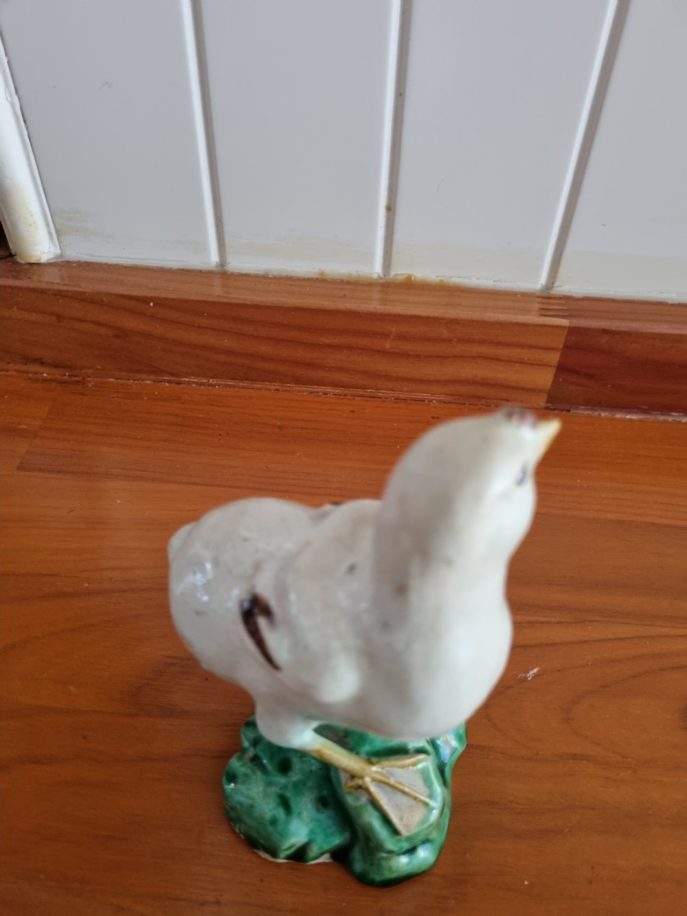 A late 18th-century Prattware glazed ceramic figure of a chicken standing on a textured green base. View V