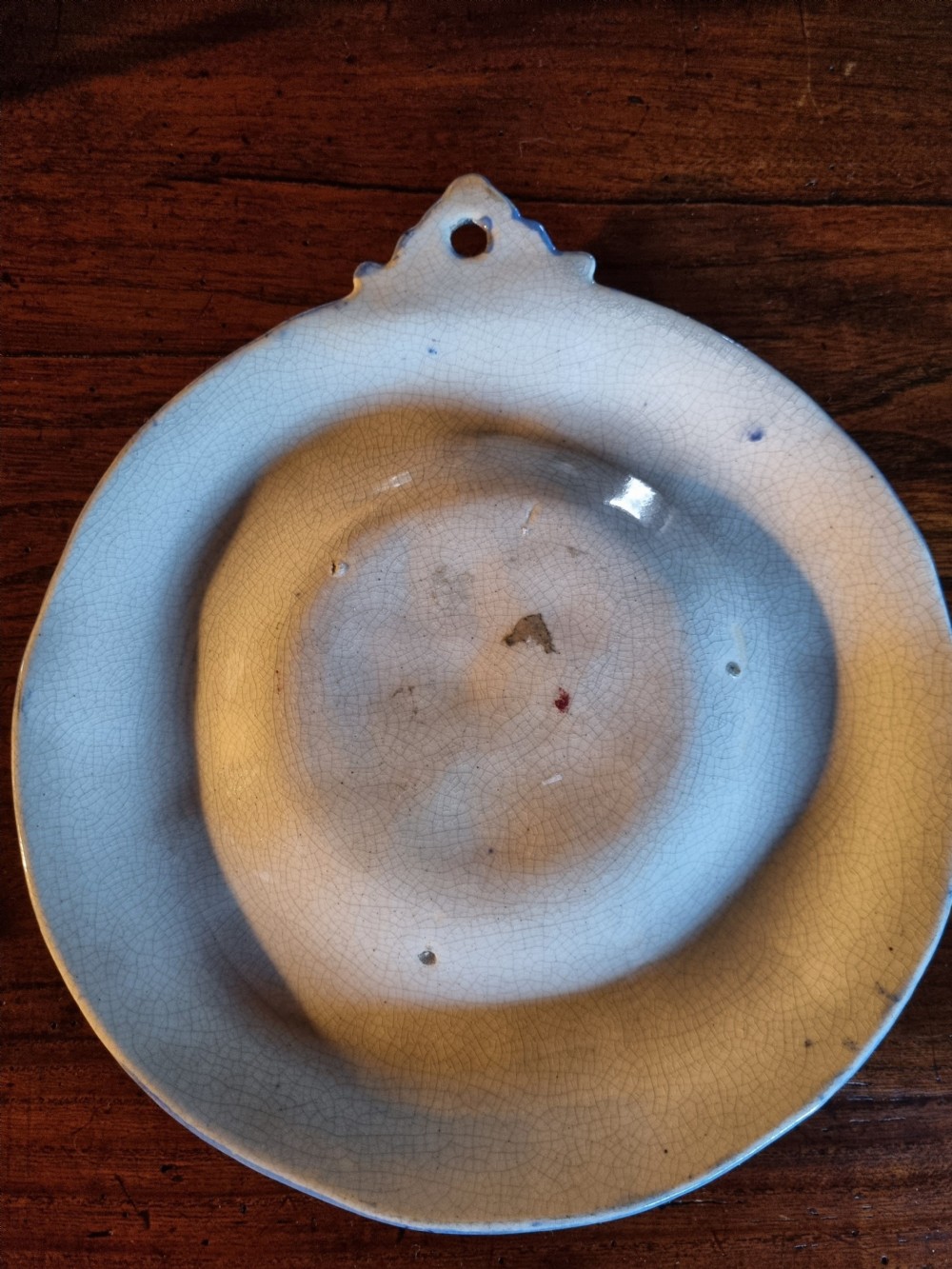 A circular nineteenth-century Scottish ceramic plaque with relief-moulded figures, lettering reading Cauld Lang Syne, and a blue and yellow glazed rim. View II