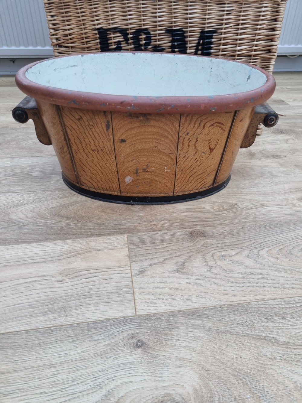 An oval nineteenth-century metal footbath featuring a hand-painted scumbled faux-wood effect, a terracotta rolled rim, and heavy side carrying handles. View VII