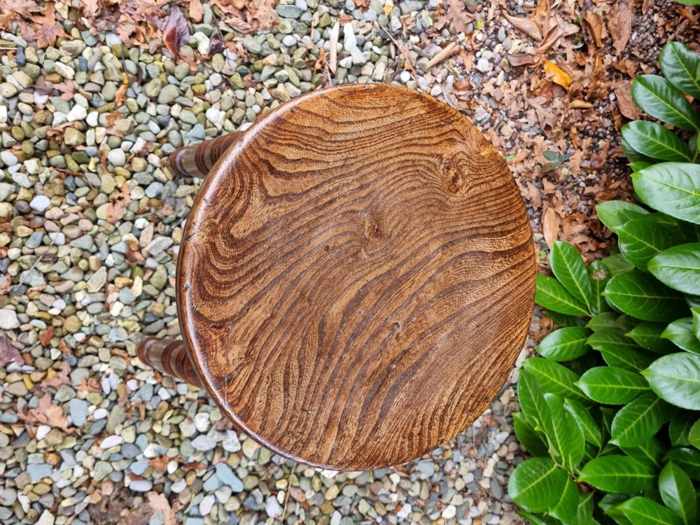A 19th-century tall wooden stool crafted from elm, featuring a circular seat, four turned legs, and cross stretchers. View II