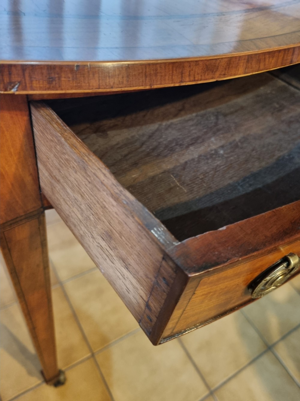 An oval Georgian drop-leaf Pembroke table crafted from inlaid satinwood with a single frieze drawer and square tapered legs on castors. View IV