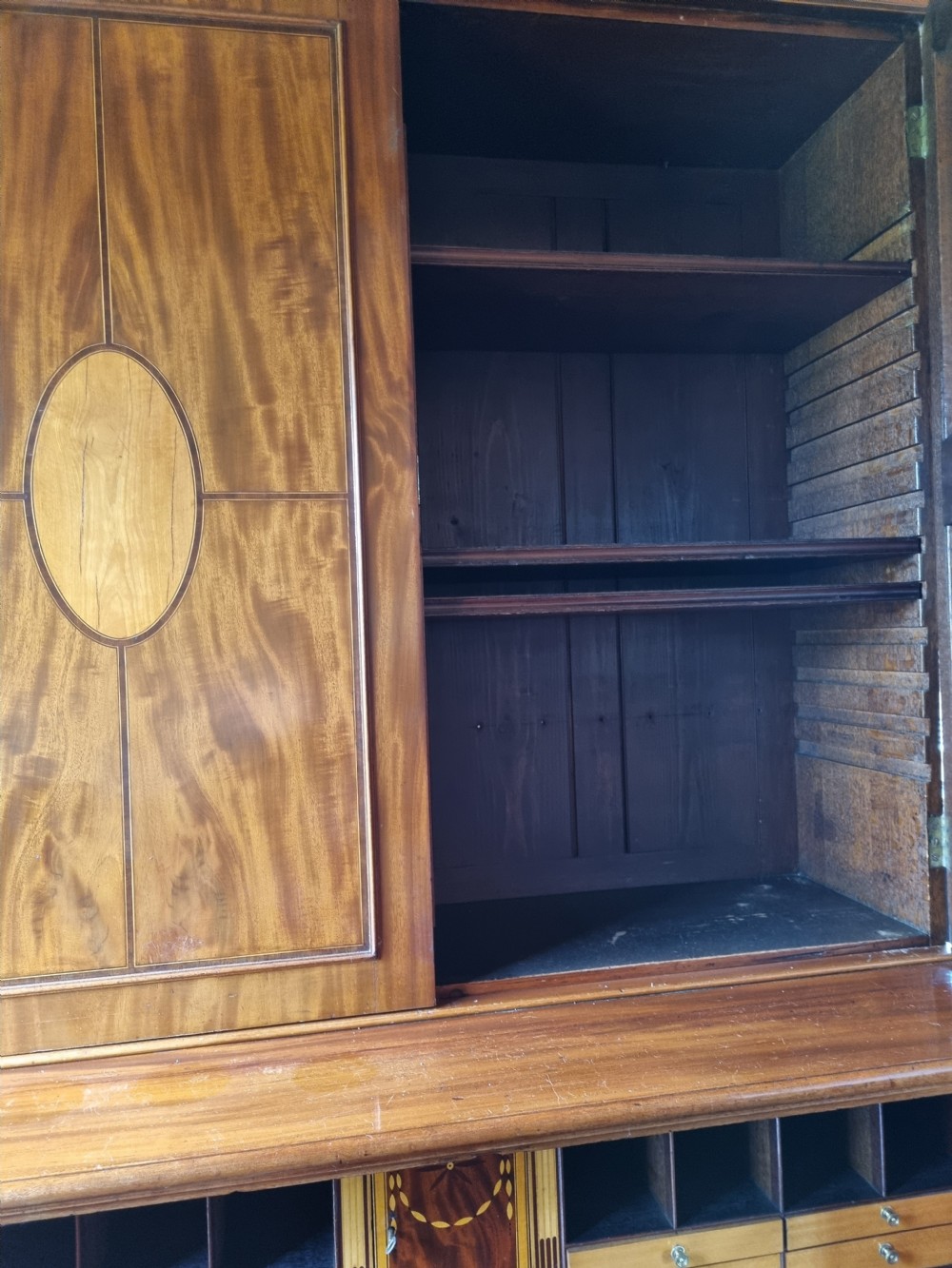 A late 18th-century mahogany secretaire cabinet featuring satinwood oval inlays on the doors, a pull-out writing drawer, and lower drawers with brass swan-neck handles. View VI