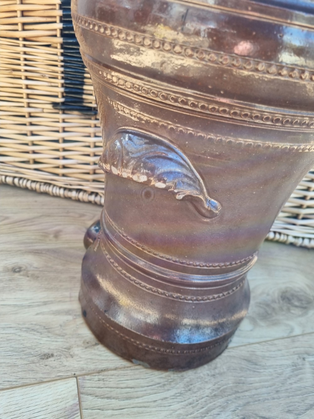 A dark brown glazed stoneware water filter featuring decorative relief moulding, a domed lid, maker markings reading Dee Filter Company Chester, and a spigot opening at the base. View III
