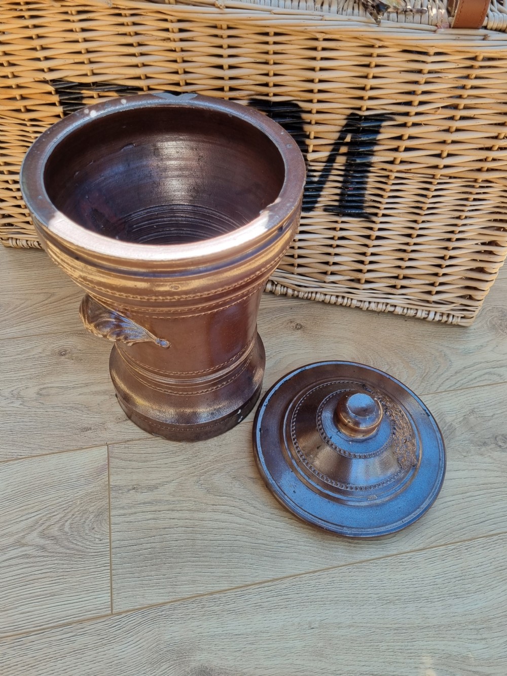 A dark brown glazed stoneware water filter featuring decorative relief moulding, a domed lid, maker markings reading Dee Filter Company Chester, and a spigot opening at the base. View IV