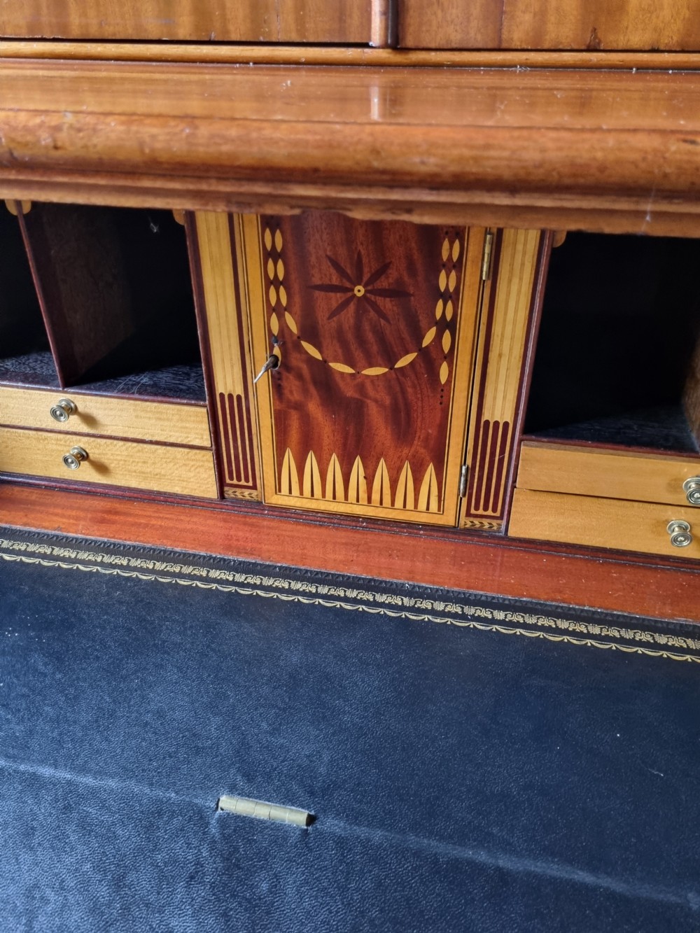 A late 18th-century mahogany secretaire cabinet featuring satinwood oval inlays on the doors, a pull-out writing drawer, and lower drawers with brass swan-neck handles. View VIII