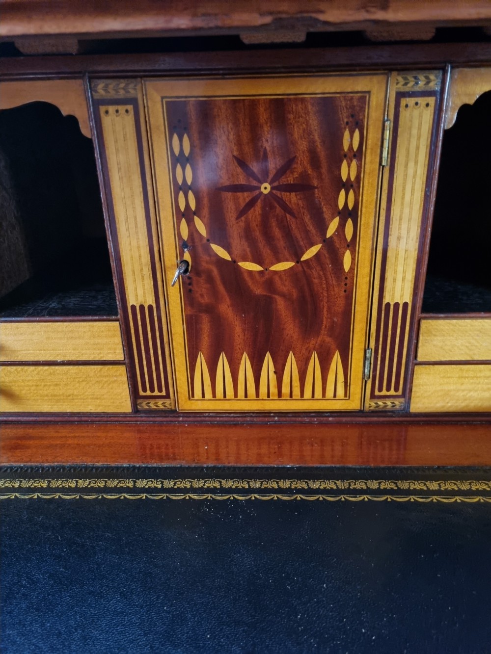 A late 18th-century mahogany secretaire cabinet featuring satinwood oval inlays on the doors, a pull-out writing drawer, and lower drawers with brass swan-neck handles. View IX
