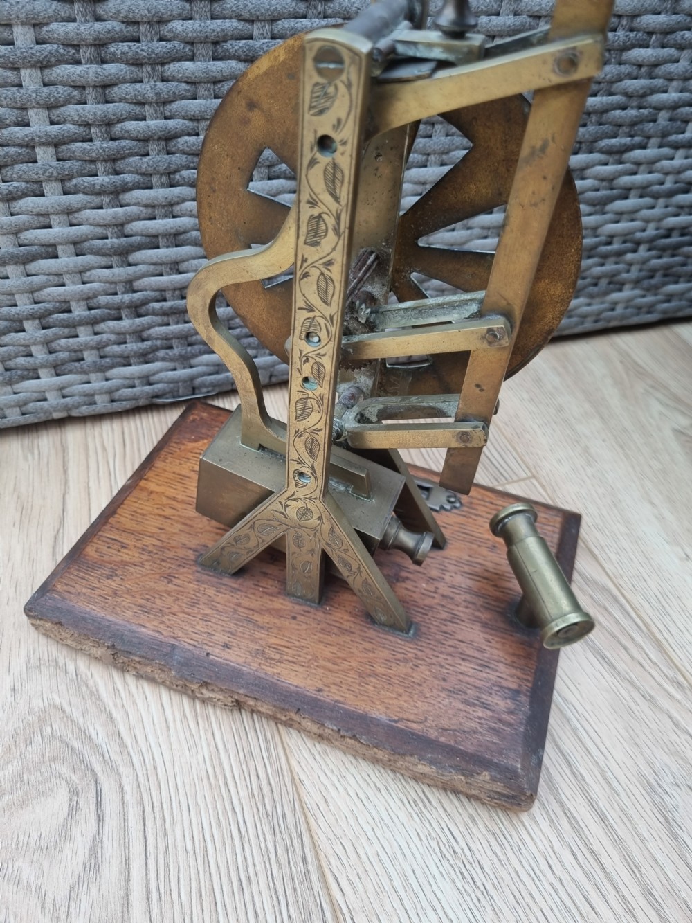 An antique brass post office parcel scale with a circular dial indicator mounted on a rectangular wooden base. View III