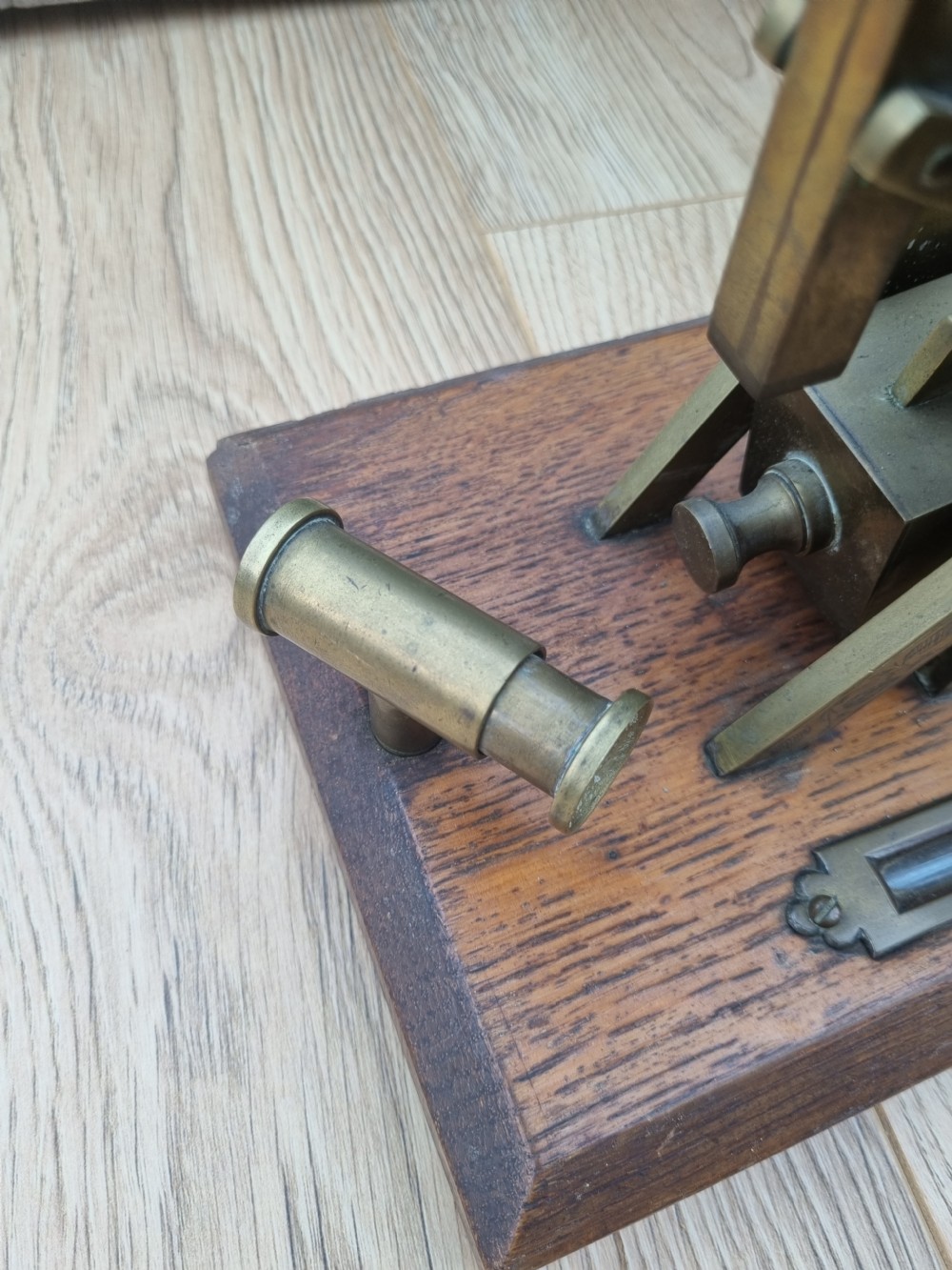 An antique brass post office parcel scale with a circular dial indicator mounted on a rectangular wooden base. View V