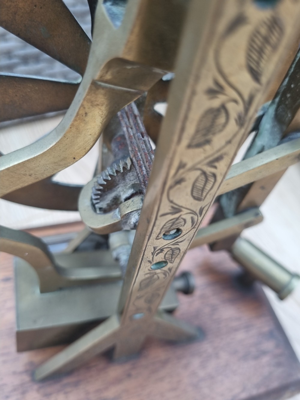An antique brass post office parcel scale with a circular dial indicator mounted on a rectangular wooden base. View VI