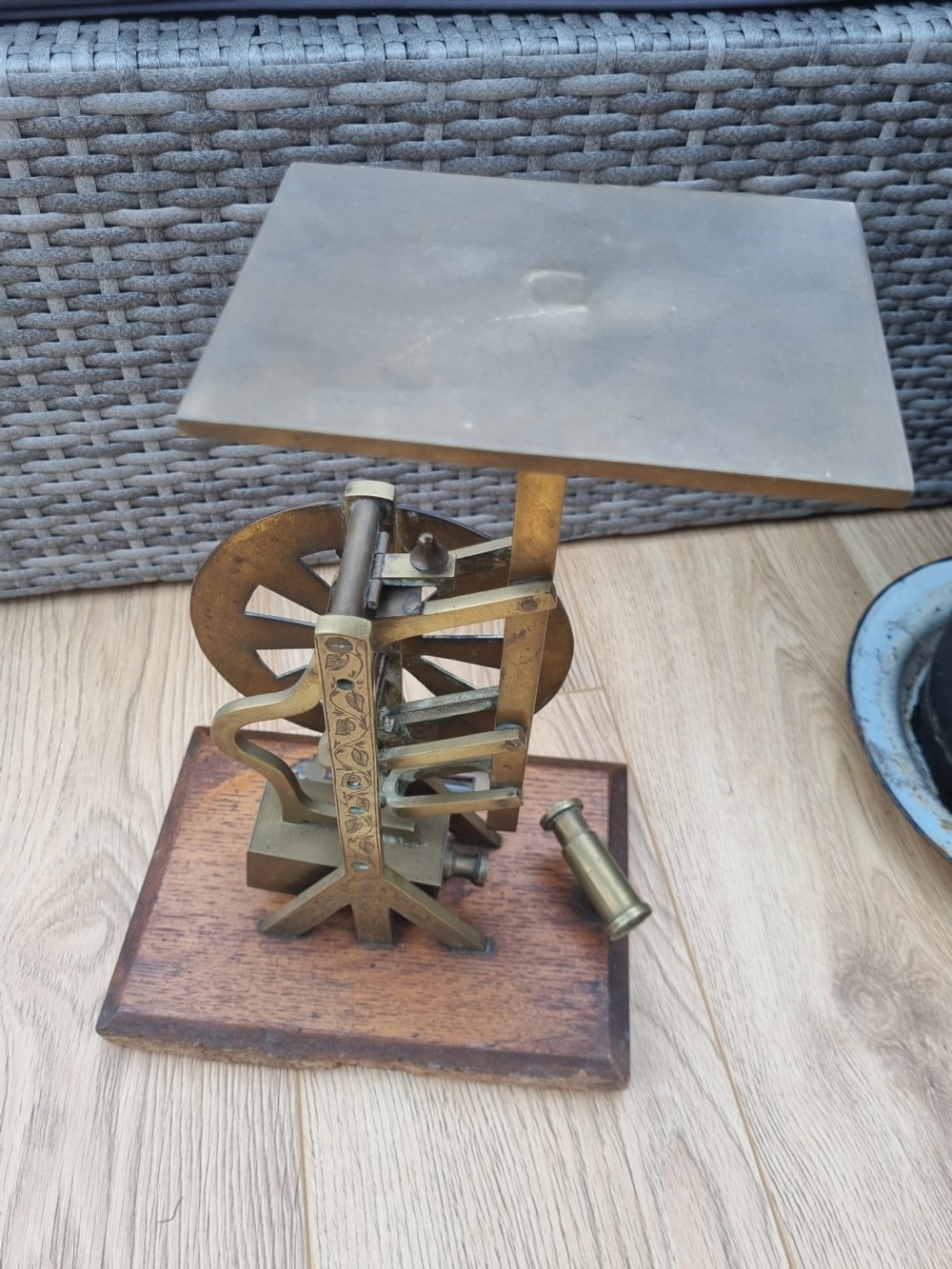 An antique brass post office parcel scale with a circular dial indicator mounted on a rectangular wooden base. View VII