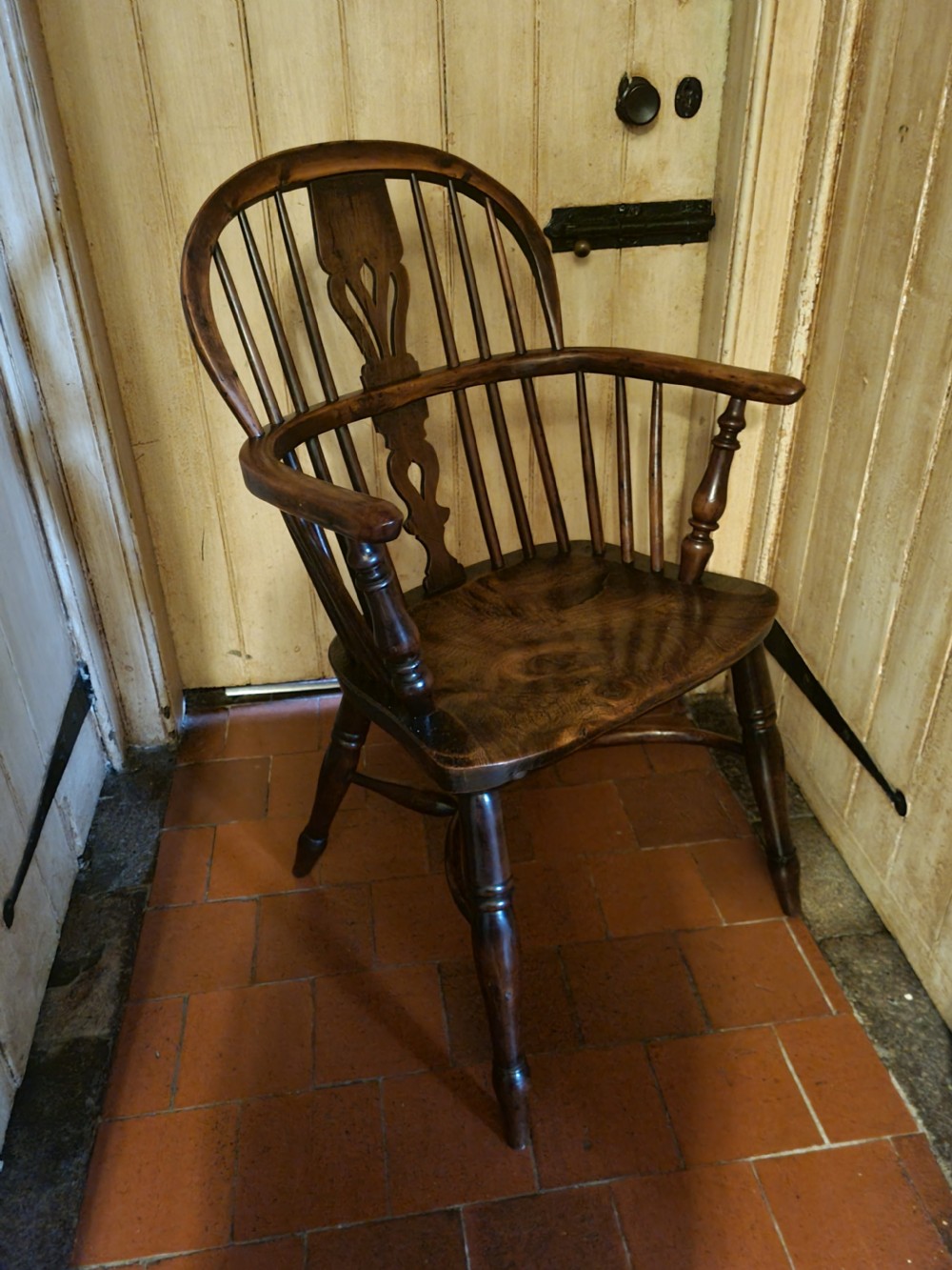 A 19th-century yew wood Windsor armchair with a hoop back, central pierced splat, turned legs, and a curved stretcher. View VI