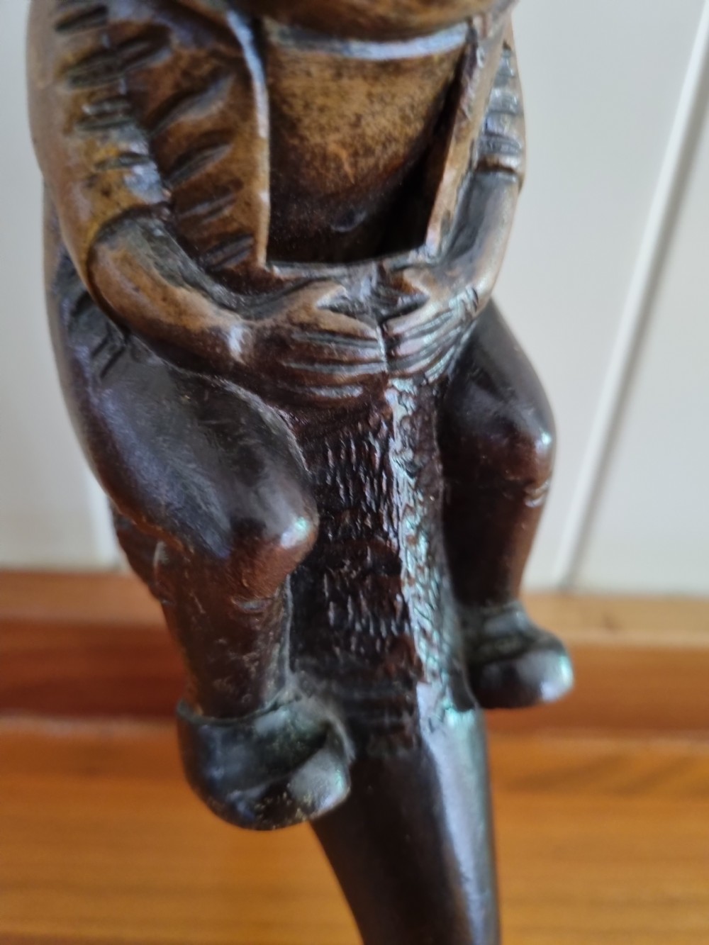 A hand-carved dark walnut nutcracker depicting a figurative hooded character with a lever mechanism. View IV