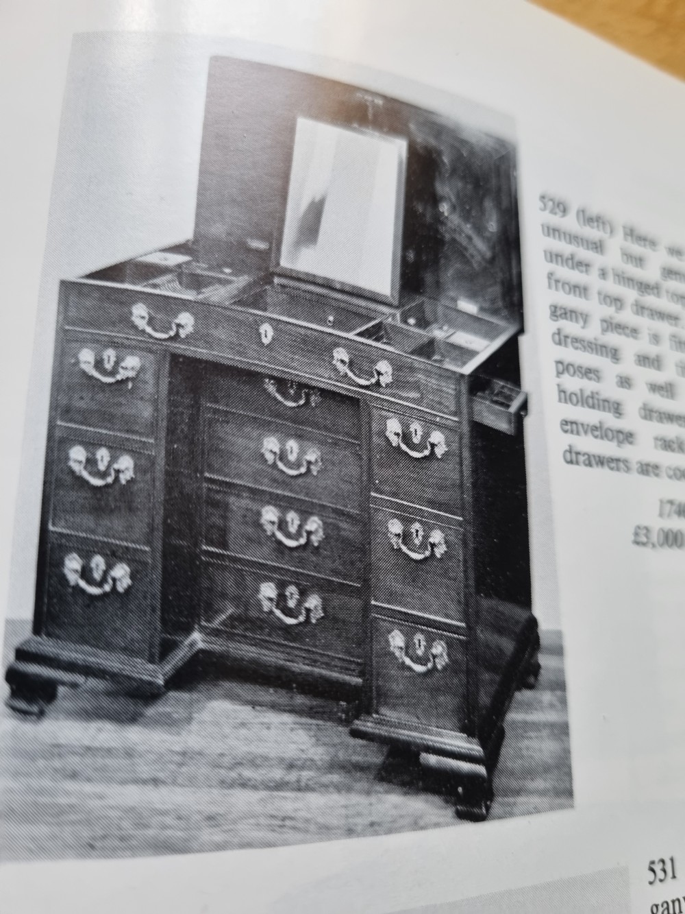 An 18th-century mahogany kneehole desk featuring a long top drawer above six smaller side drawers and a central recessed cupboard on bracket feet. View III