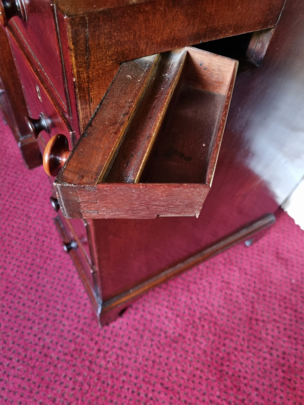 An 18th-century mahogany kneehole desk featuring a long top drawer above six smaller side drawers and a central recessed cupboard on bracket feet. View VII