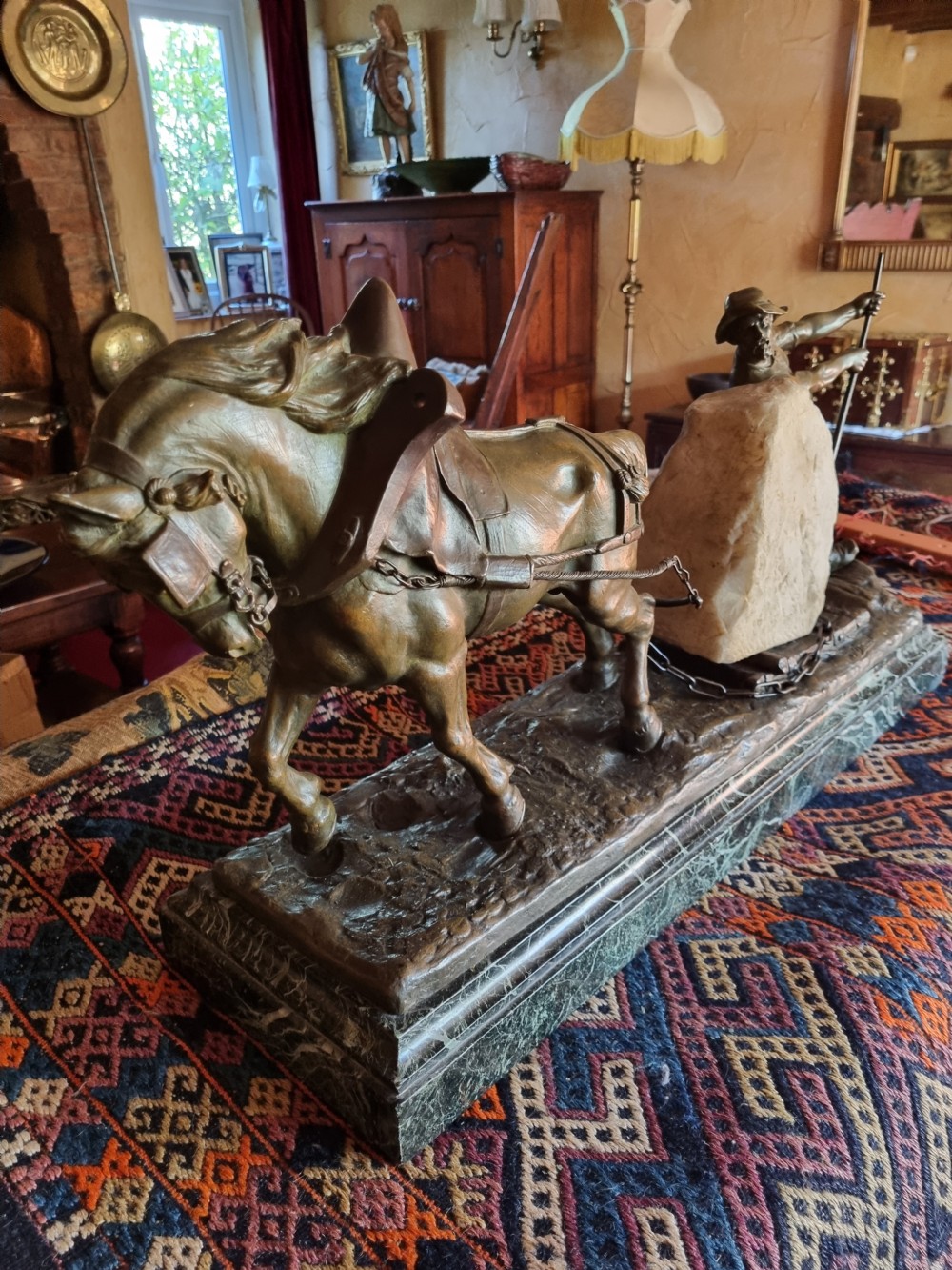 A late 19th-century patinated bronze sculpture depicting a harnessed horse pulling a stone quarry sled alongside a worker, mounted on a green marble base. View V