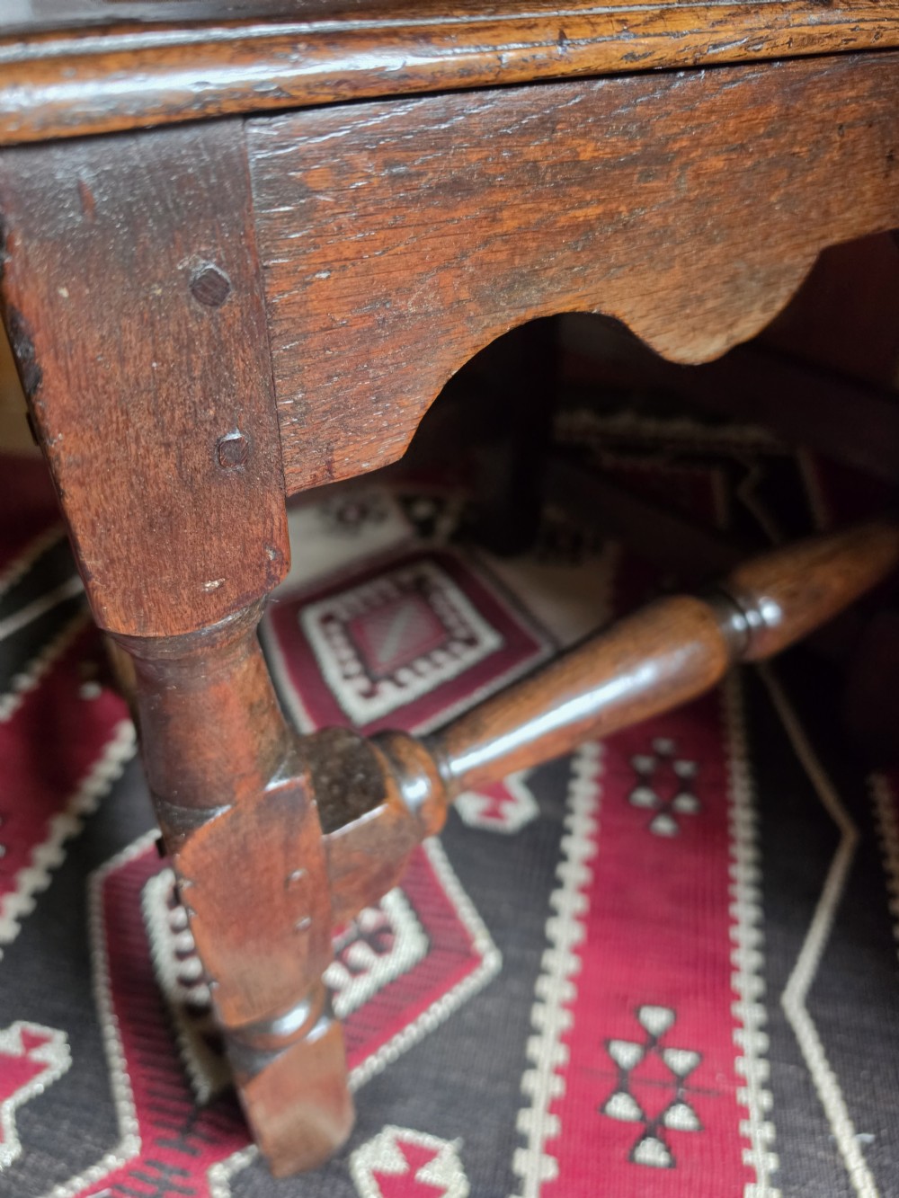 An 18th-century dark oak side chair featuring a vase-shaped splat back, solid timber seat, and turned front legs and stretcher. View II