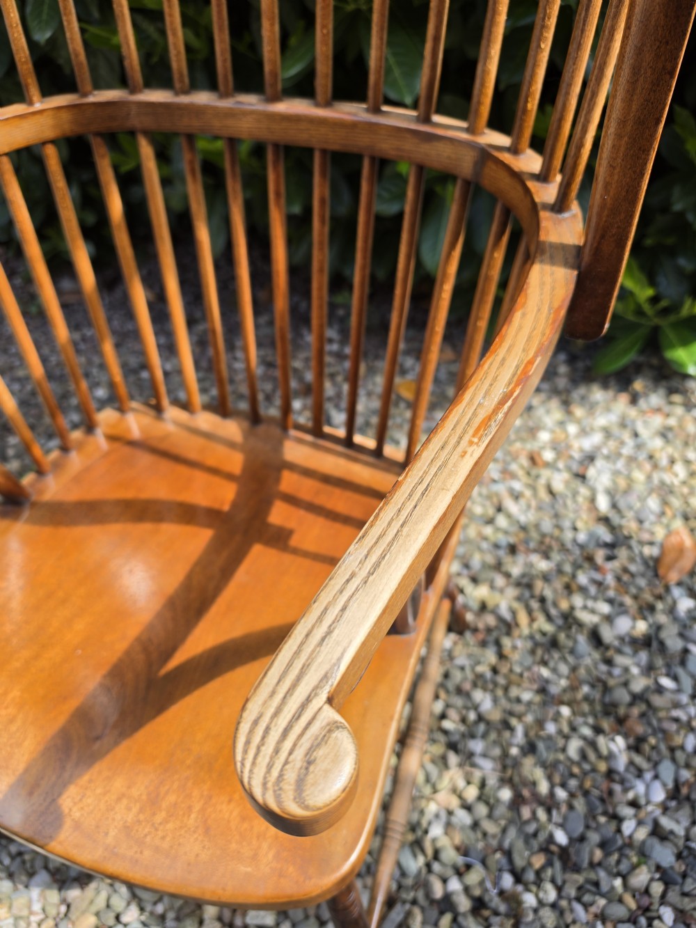 A late nineteenth-century ash and elm winged Windsor armchair featuring vertical back spindles, swept armrests, a shaped saddle seat, and turned wooden legs. View II