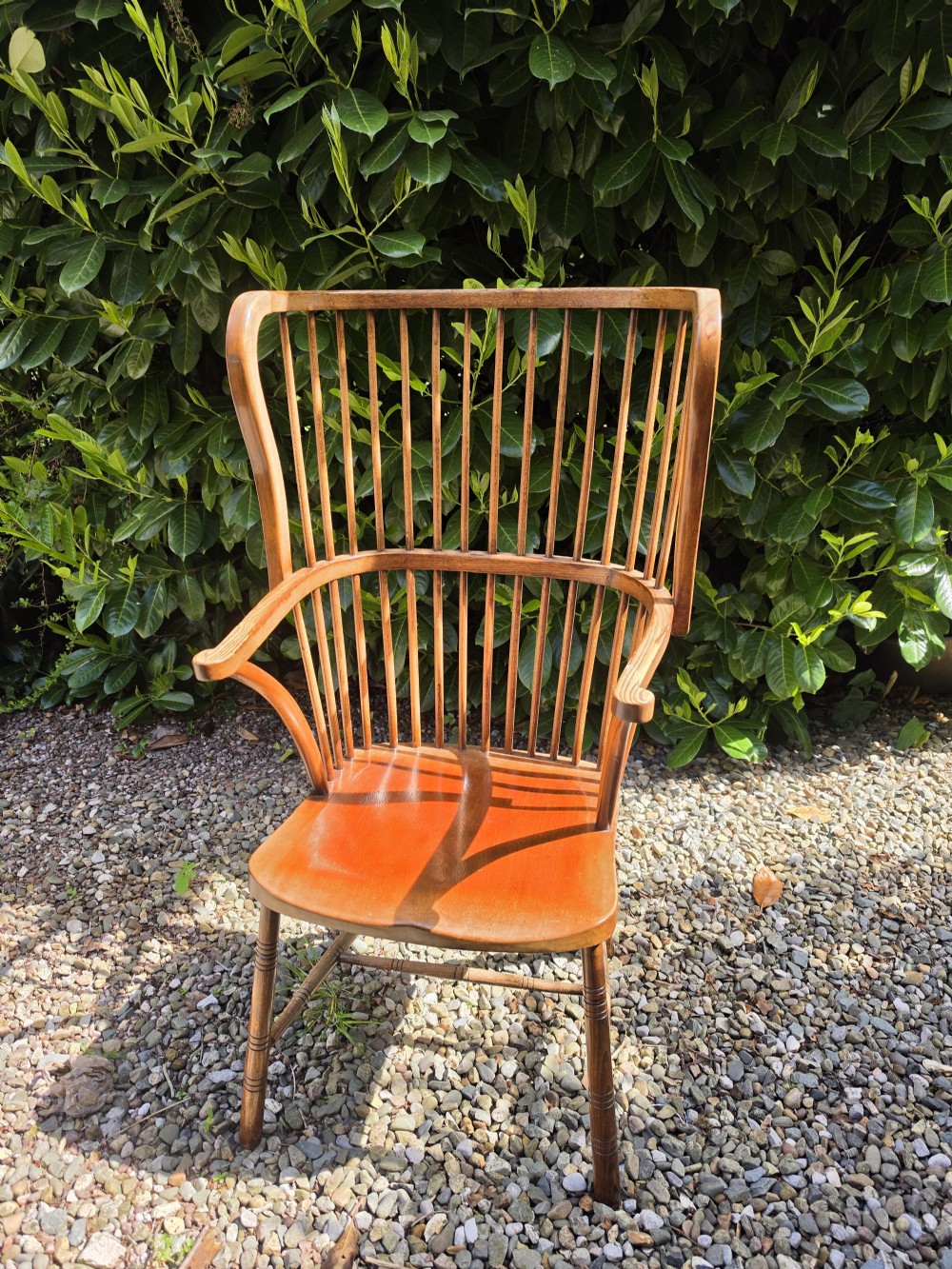 A late nineteenth-century ash and elm winged Windsor armchair featuring vertical back spindles, swept armrests, a shaped saddle seat, and turned wooden legs. View III