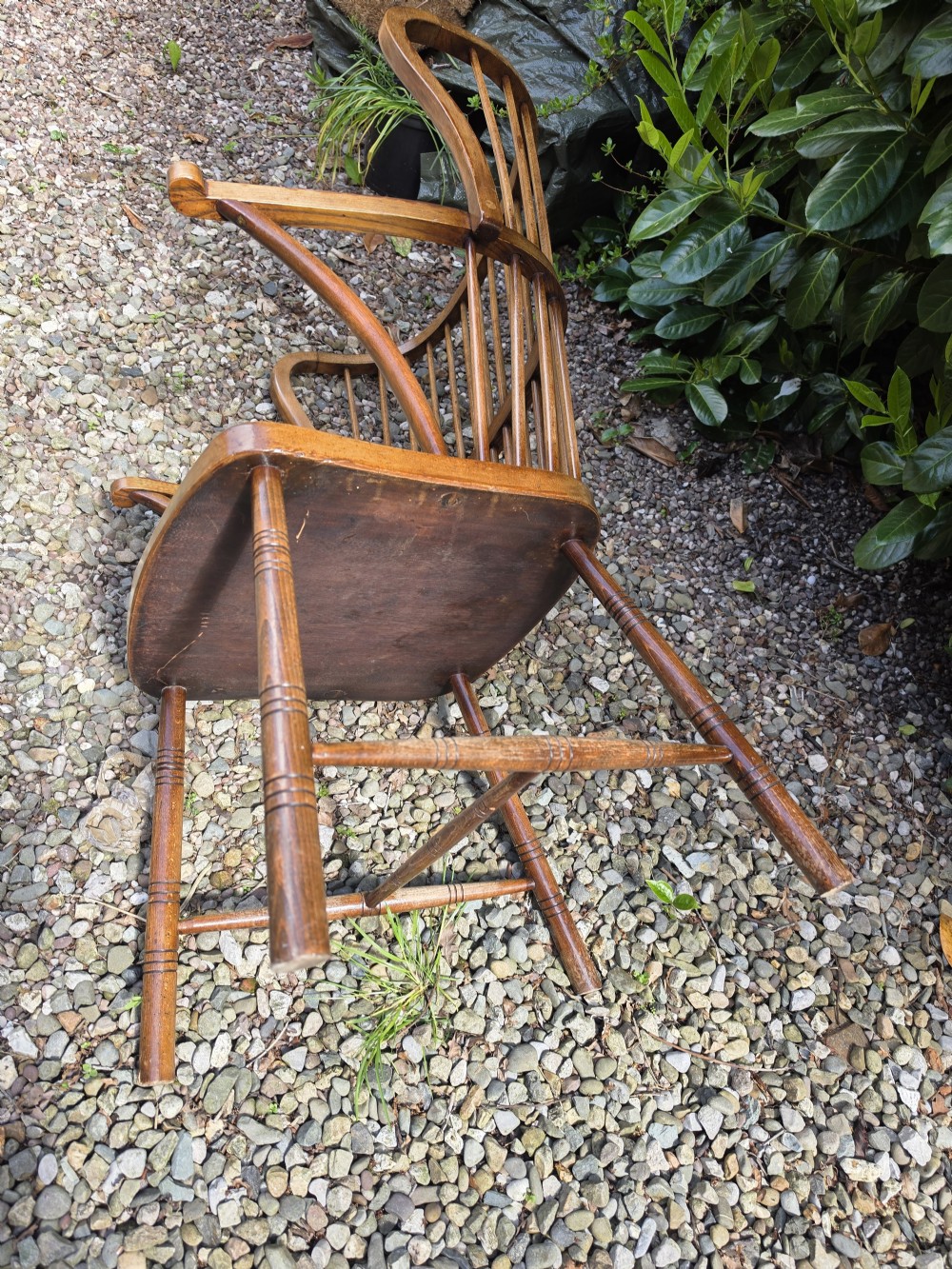 A late nineteenth-century ash and elm winged Windsor armchair featuring vertical back spindles, swept armrests, a shaped saddle seat, and turned wooden legs. View V