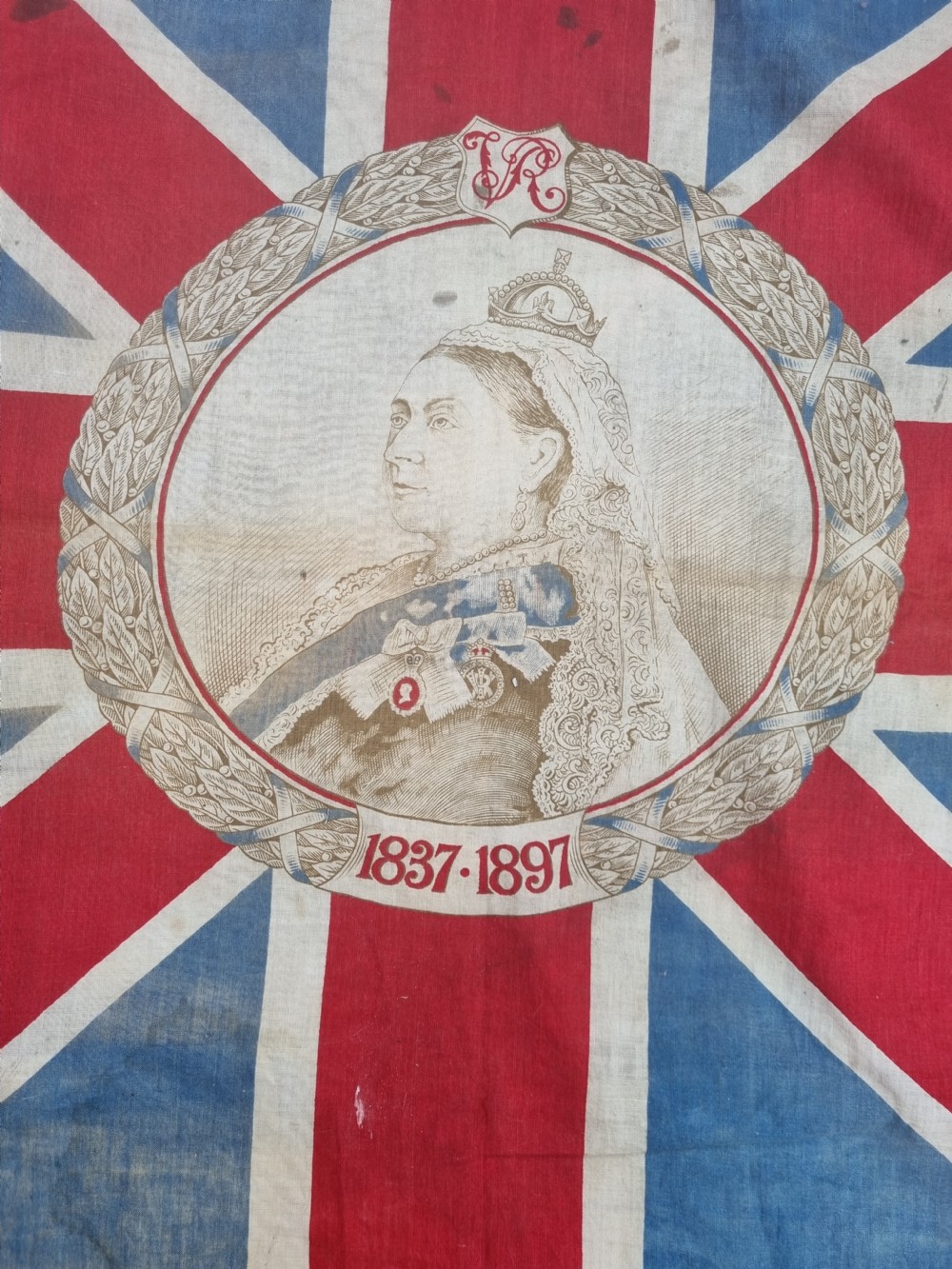 A square printed Union Jack flag featuring a central circular portrait of Queen Victoria inscribed with the dates 1837 to 1897. View III