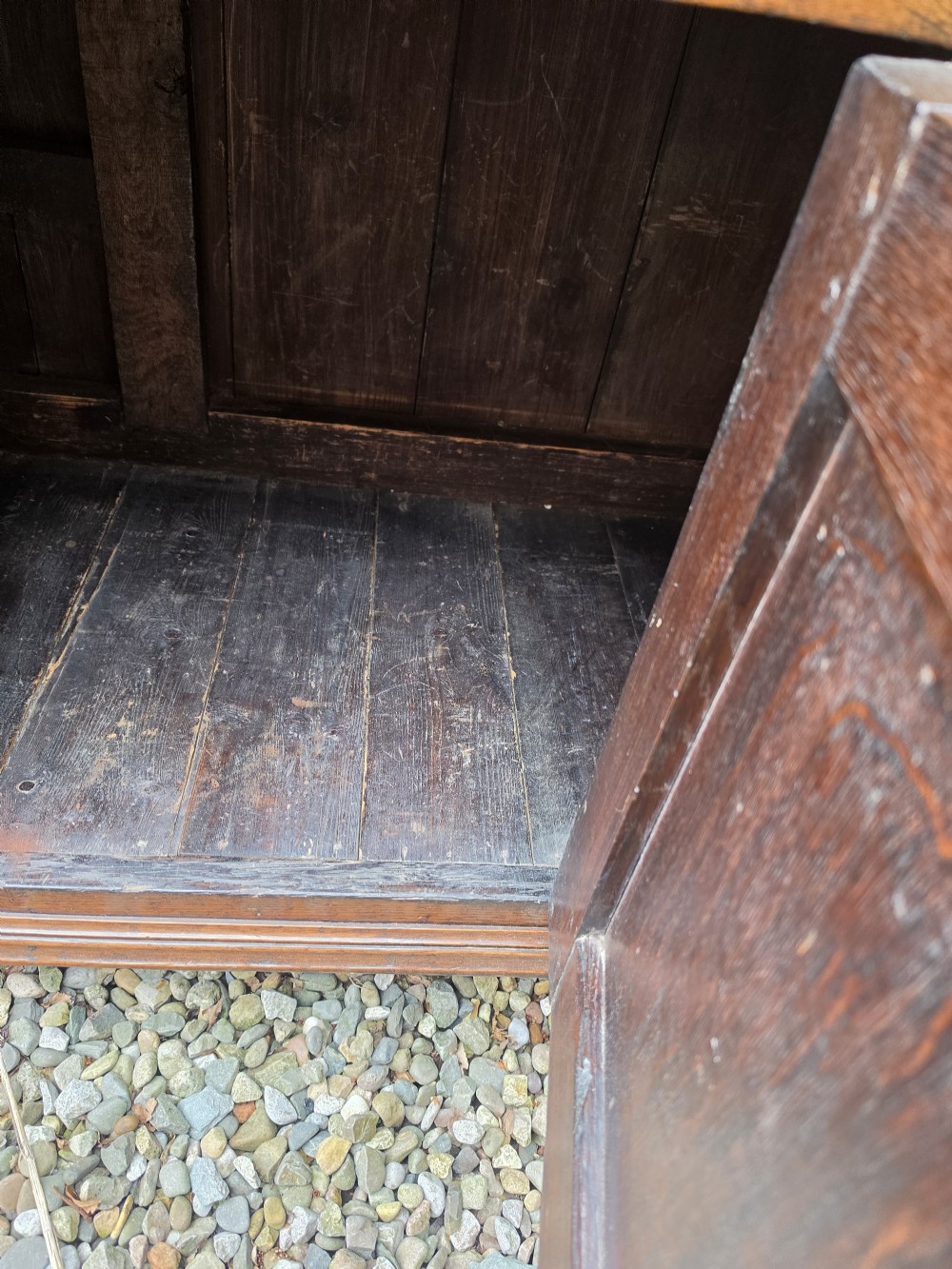 A Georgian dark oak dresser base featuring three top drawers over geometric moulded panel doors on bracket feet. View III