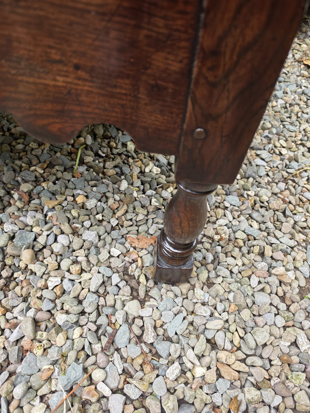 A mid-18th-century Georgian oak dresser base featuring three frieze drawers with brass swan-neck handles, a shaped apron, and turned front legs. View IV