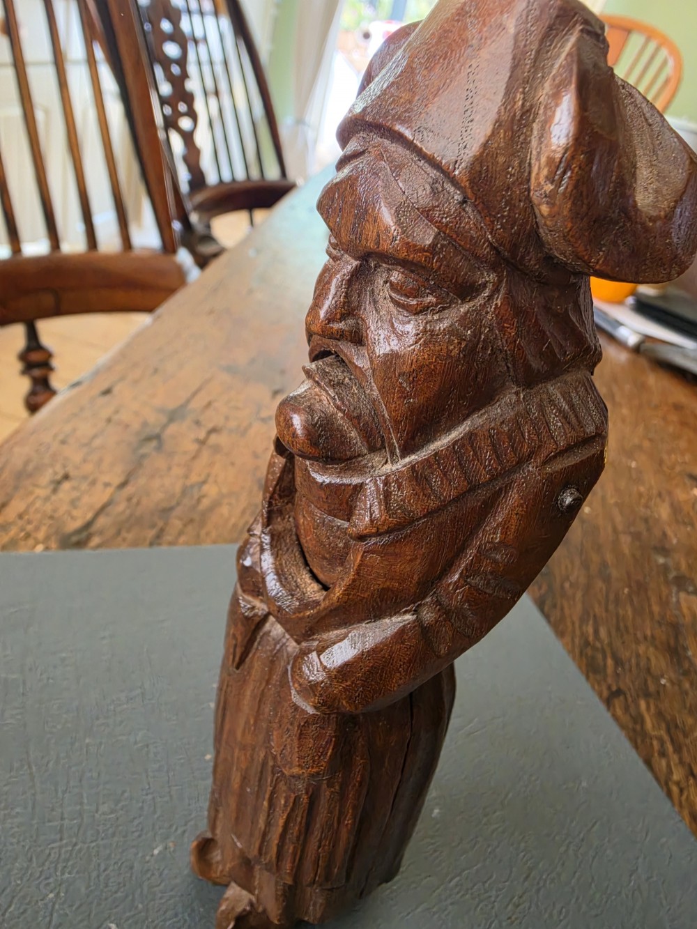 A hand-carved dark oak nutcracker depicting a standing human figure with an open mouth mechanism. View VI
