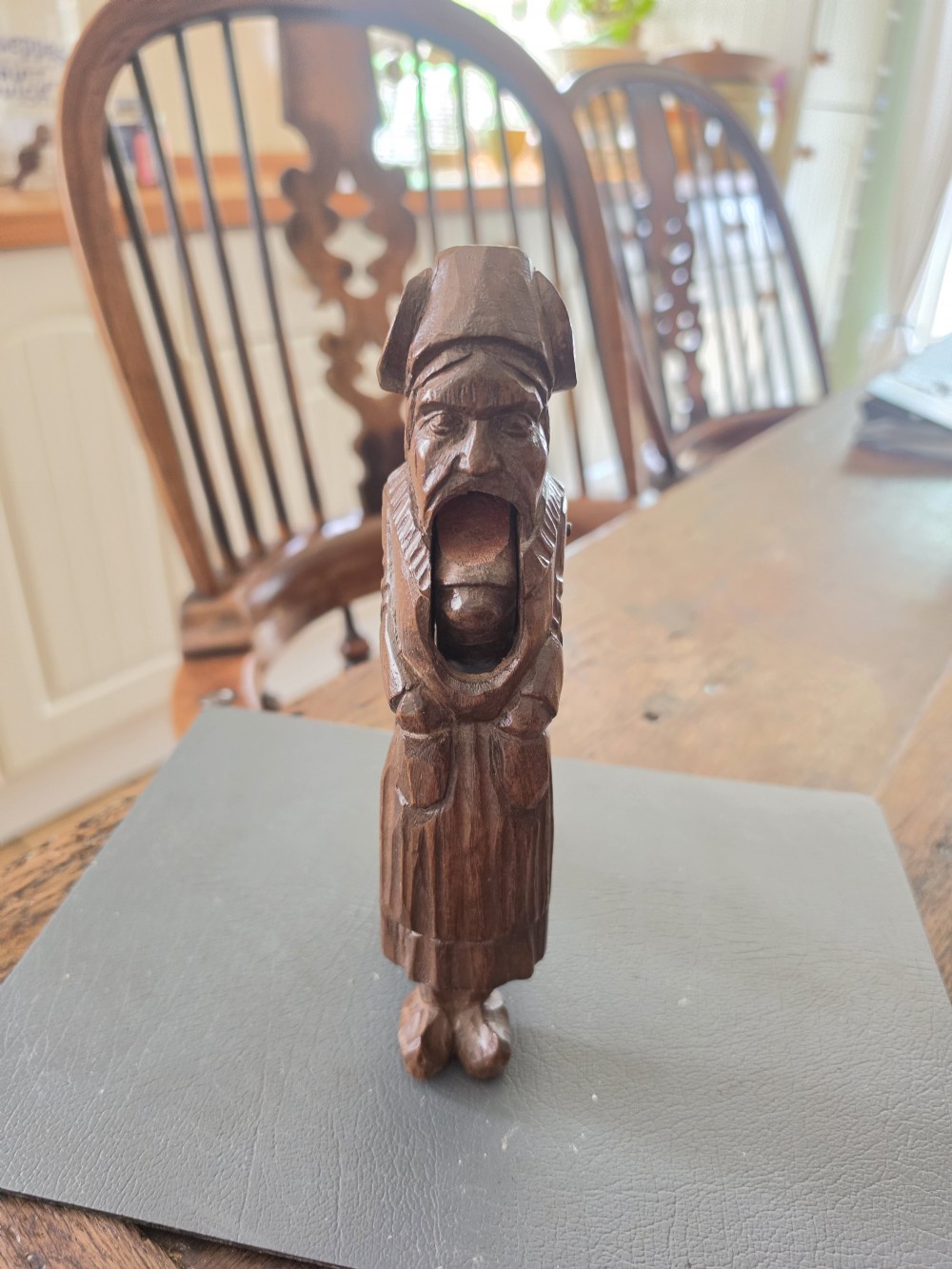 A hand-carved dark oak nutcracker depicting a standing human figure with an open mouth mechanism. View VII
