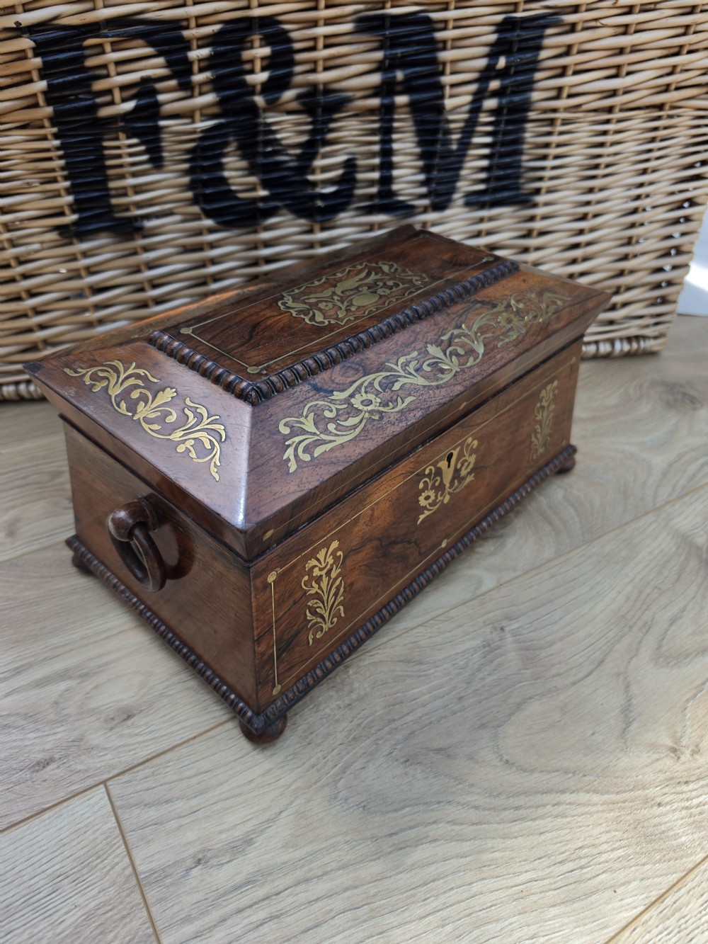 A Regency period dark rosewood tea caddy featuring ornate brass floral scrollwork inlay, gadrooned borders, and a central bird motif on the hinged lid. View III