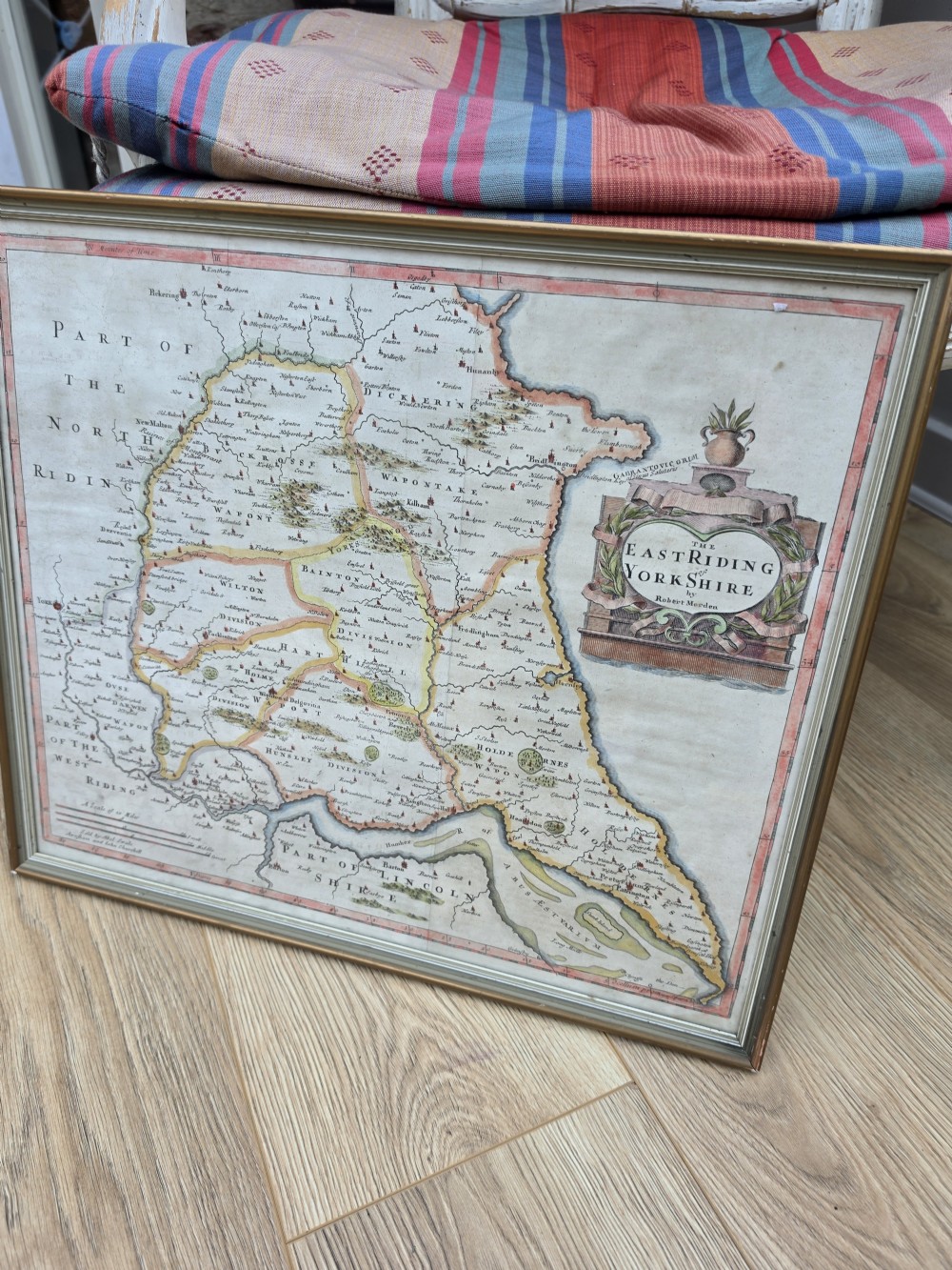 A framed 17th-century hand-coloured engraved map of the East Riding of Yorkshire featuring a decorative cartouche and thin gold border. View VI