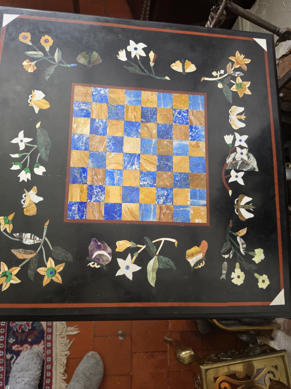 A pair of 19th-century occasional tables featuring square black marble tops inlaid with colourful pietra dura chessboard patterns and floral borders on carved giltwood pedestal bases. View III