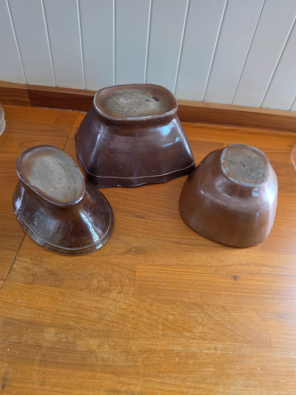 A set of three 19th-century brown stoneware jelly moulds featuring interior relief carvings of a crown crest, a rabbit, and a bird. View V