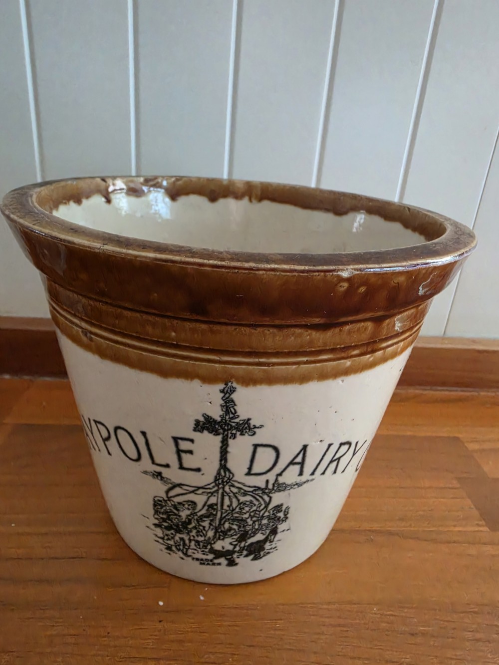 A Victorian cream stoneware dairy crock featuring a brown glazed rim and black transfer-printed Maypole Dairy lettering and illustration. View II