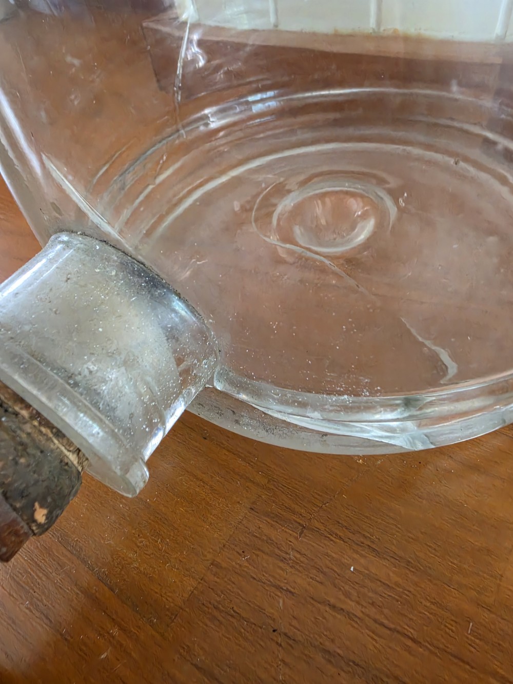 A large clear glass Schweppes fruit juice dispenser featuring printed lettering, a pointed finial lid, and a metal tap at the base. View IV
