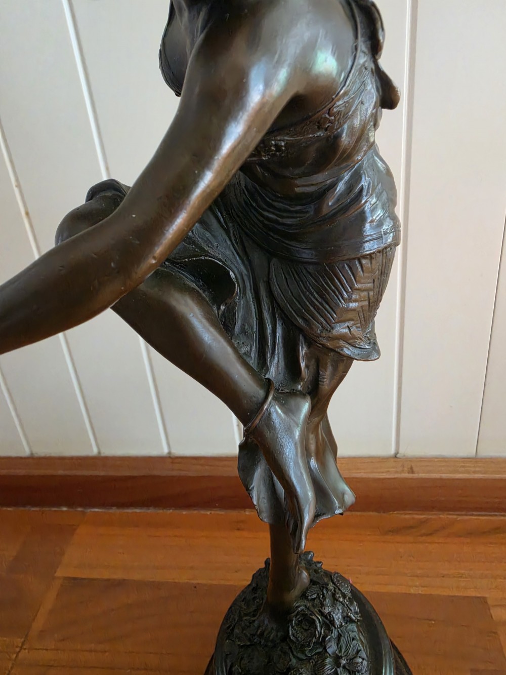 A dark patinated bronze figure depicting a female dancer in mid-motion with raised arms, standing balanced on a circular base. View V
