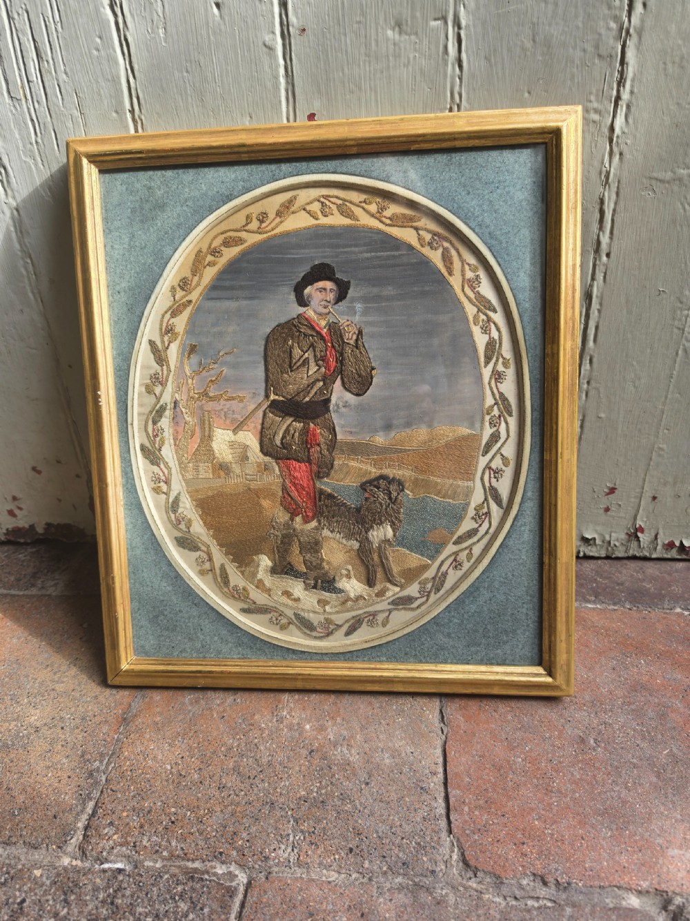 LARGE GEORGIAN WOOL AND SILKWORK PICTURE OF A WOODMAN AND DOG