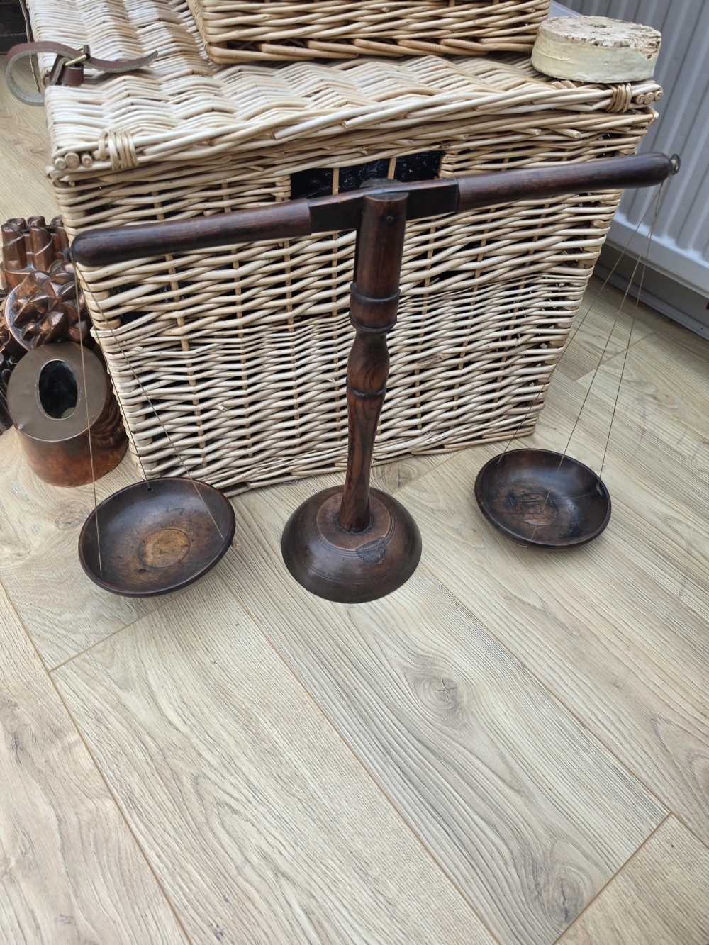 A 19th-century turned dark wood treen balance scale set with a central column, horizontal crossbar, and two suspended wooden pans. View III