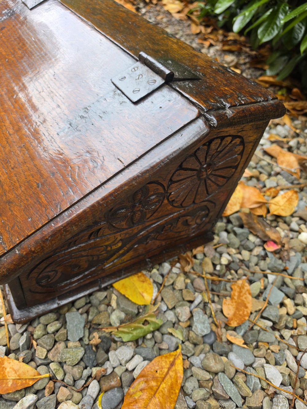A late seventeenth-century dark oak slant-front Bible box featuring hand-carved scrollwork on the front panel and dark iron strap hinges. View VII