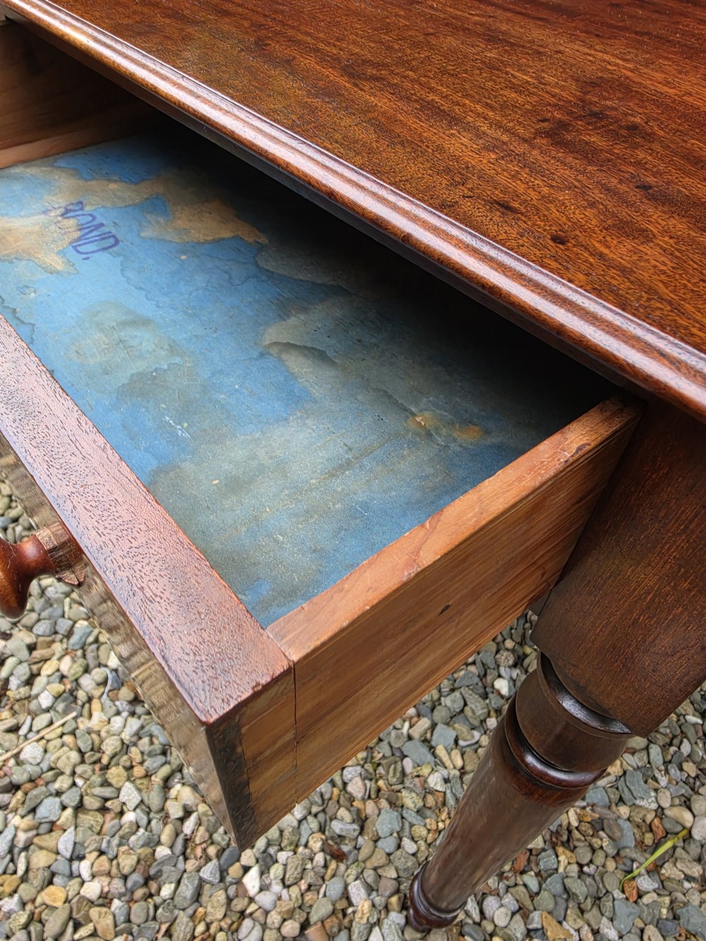 An antique Georgian mahogany side table featuring two drawers with turned wooden knobs, four turned legs, and a high curved gallery back. View VII