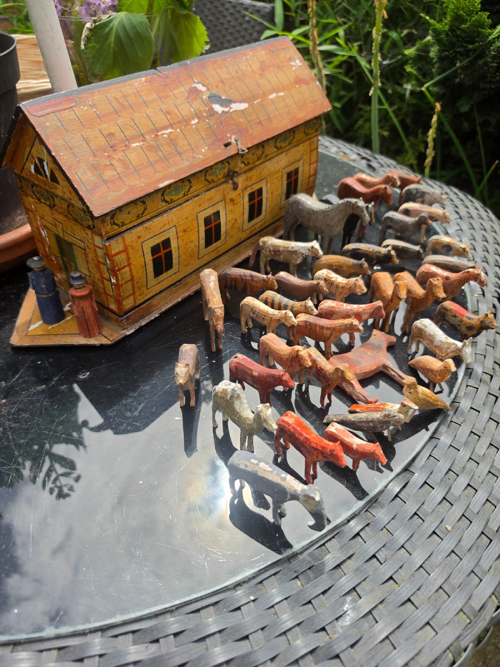 A 19th-century German painted wooden Noahs ark structure accompanied by two human figures and forty miniature hand-carved wooden animals.
