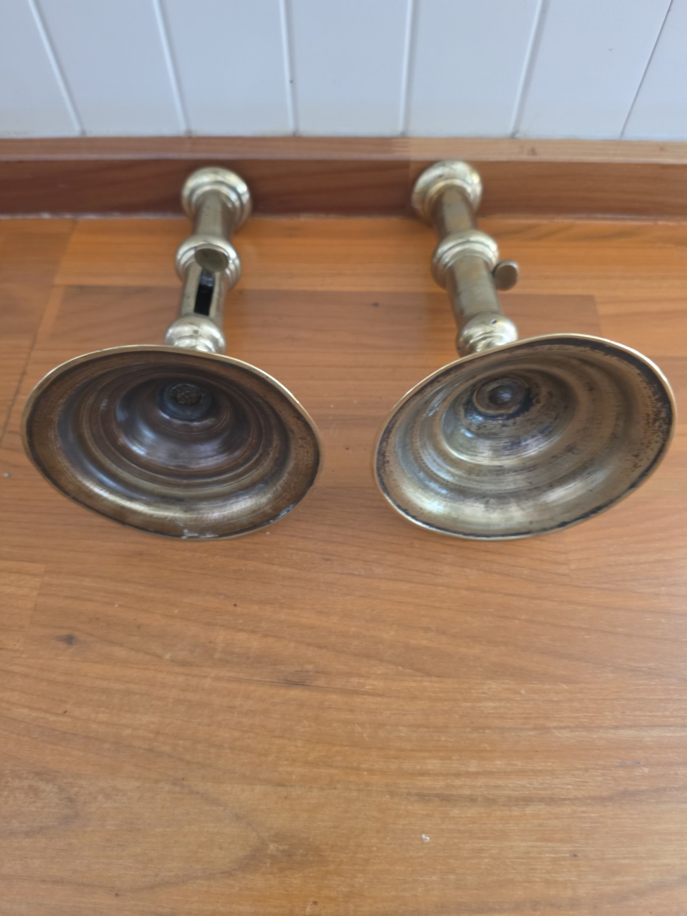 A pair of mid-18th-century seamed brass candlesticks featuring turned stems, slide ejector mechanisms, and circular stepped bases. View II