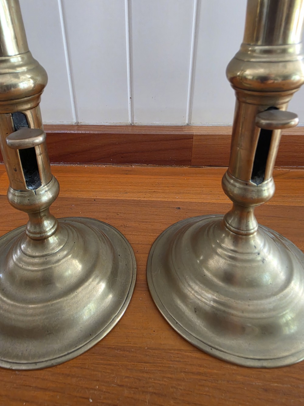 A pair of mid-18th-century seamed brass candlesticks featuring turned stems, slide ejector mechanisms, and circular stepped bases. View III